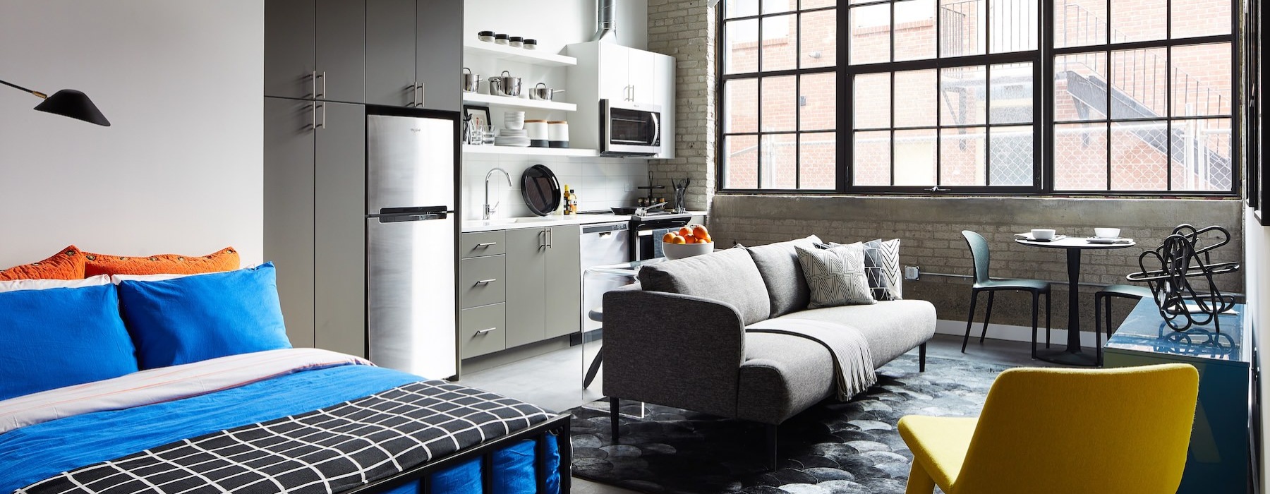 a studio with a bed, couch and chair