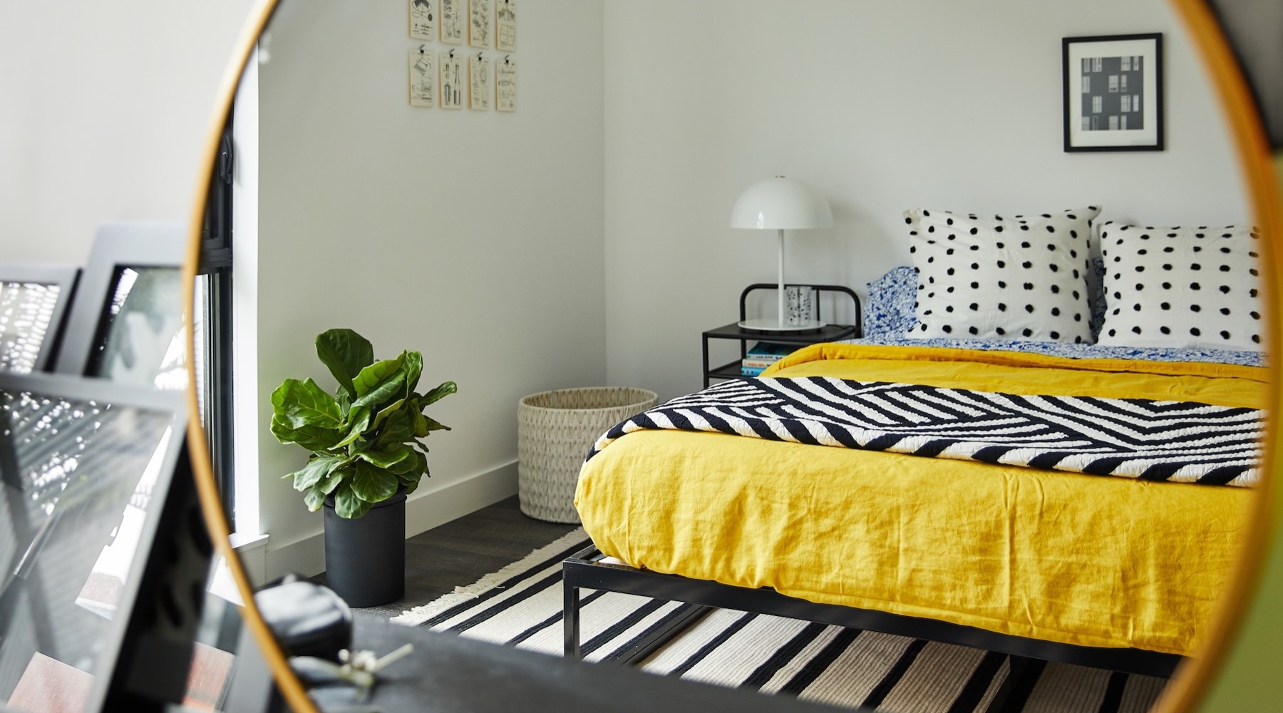 a bed with a plant reflected in a mirror