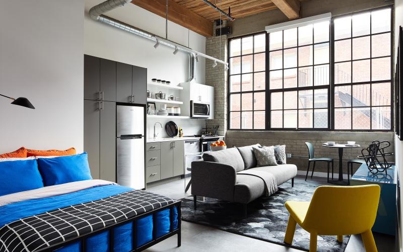 a studio with a bed, couch and chair