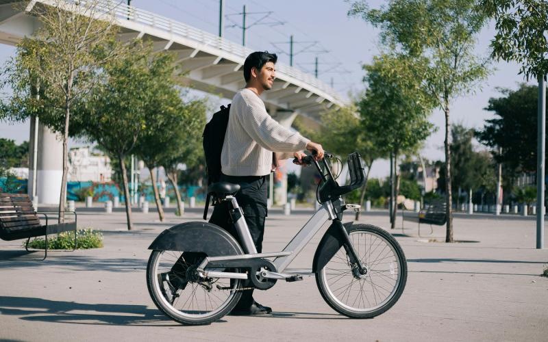A man walking with a city bike.
